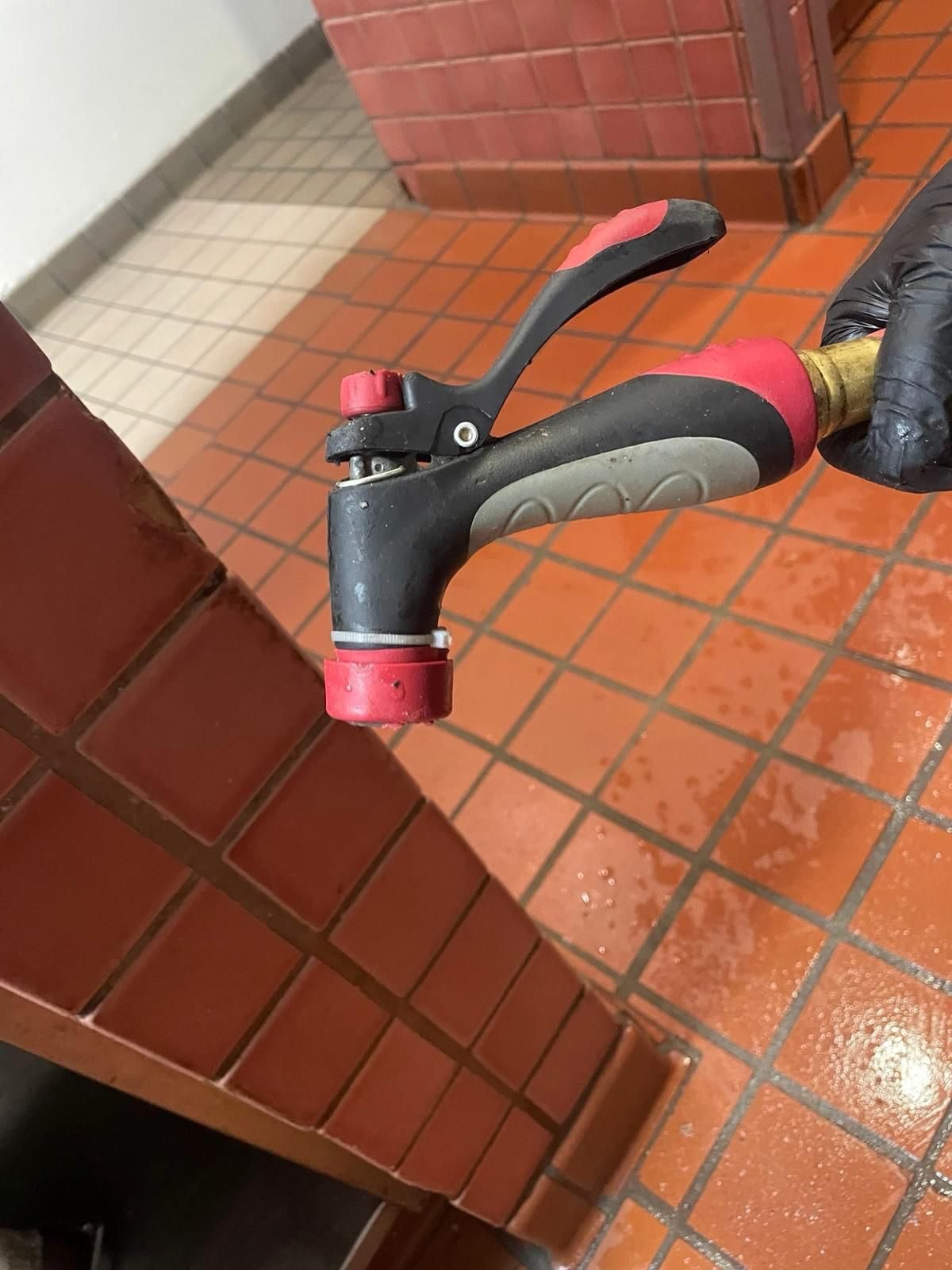 Pressure washer nozzle in use on a tiled floor