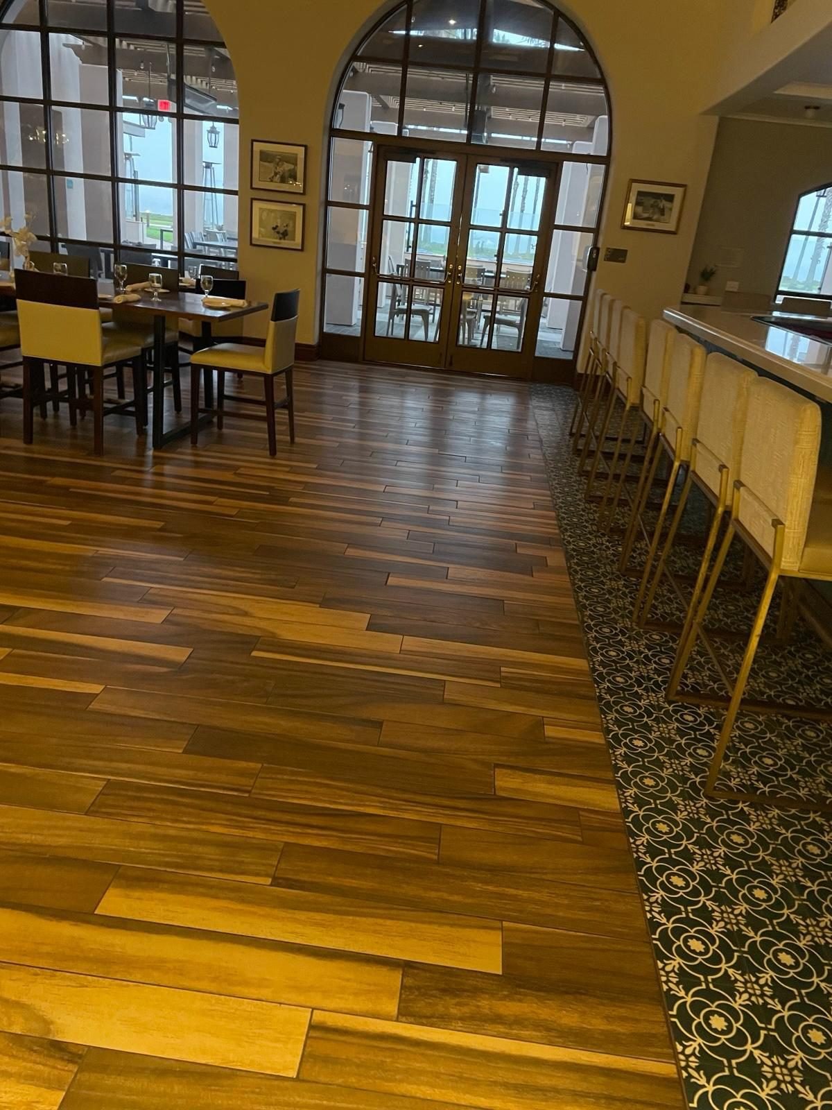 Restaurant dining room with a polished wood floor and set tables