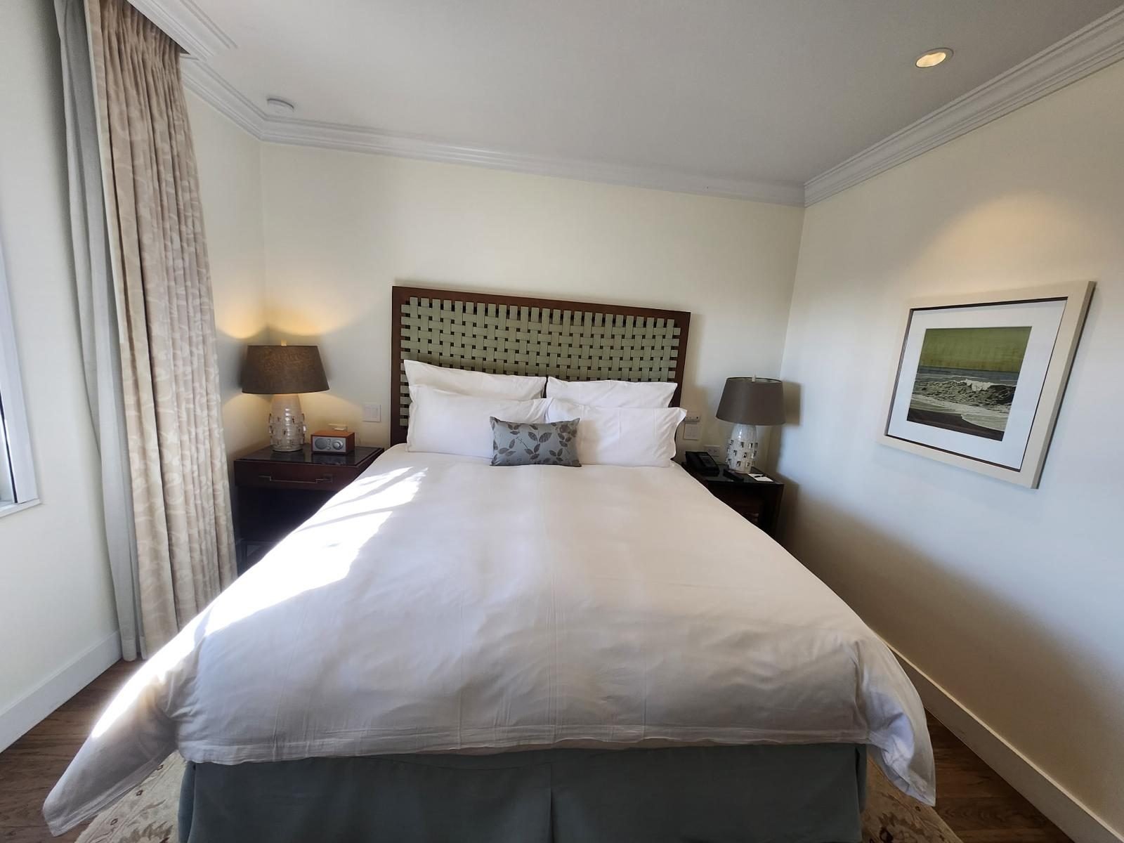 Bedroom with the bed made, folded linen and bedside lamps