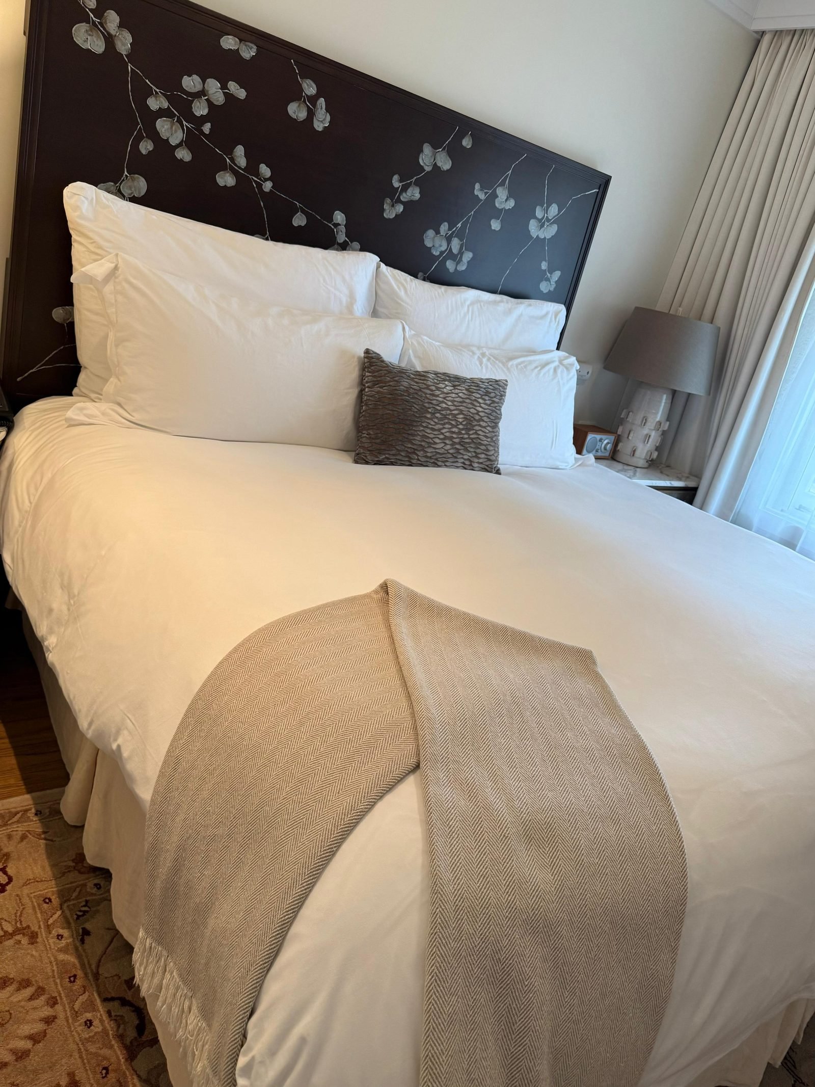 Bedroom with the bed made and a patterned headboard